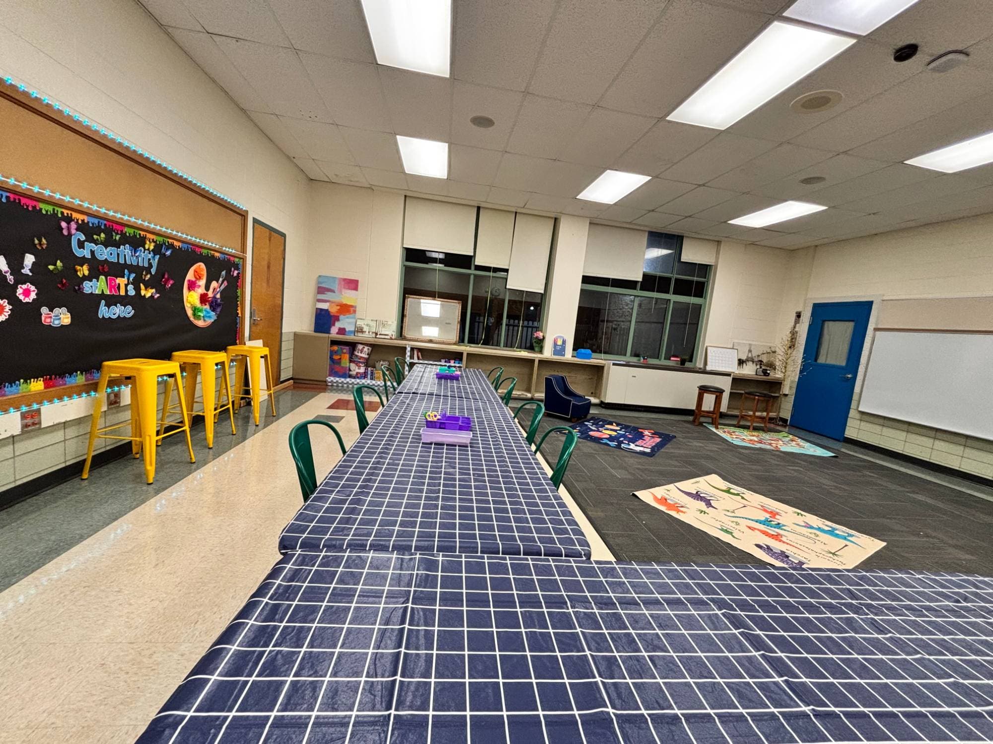 The Art Space classroom with craft tables set up and a colorful 'Creativity stARTs here' bulletin board